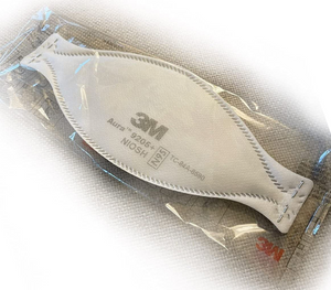 A white 3M 9205 N95 mask individually packaged with a blue nose clip and ear loops, laying flat on a white 